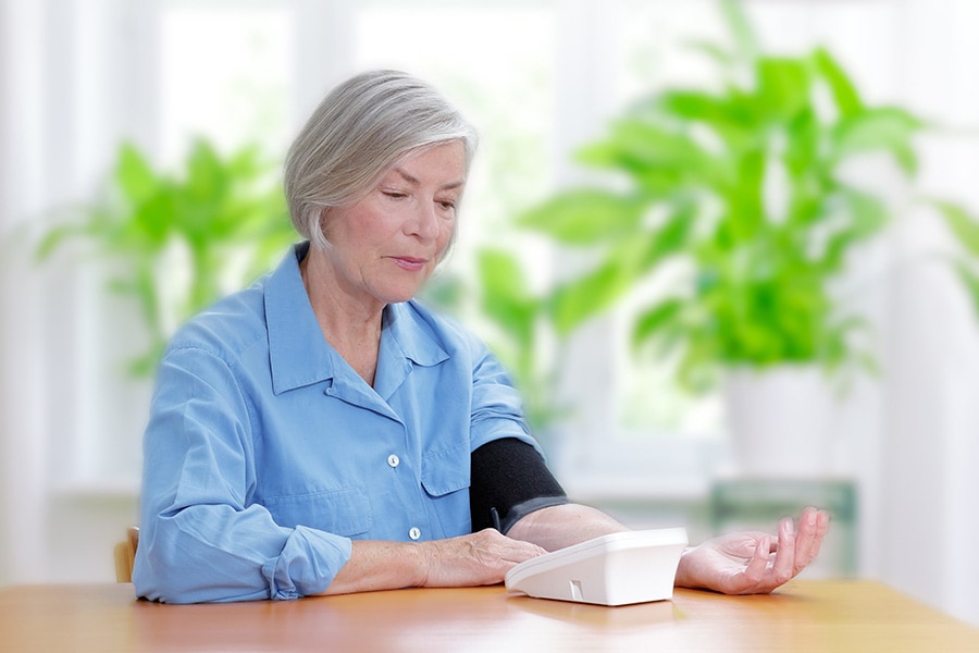 Kobieta w podeszłym wieku mierząca ciśnienie tętnicze