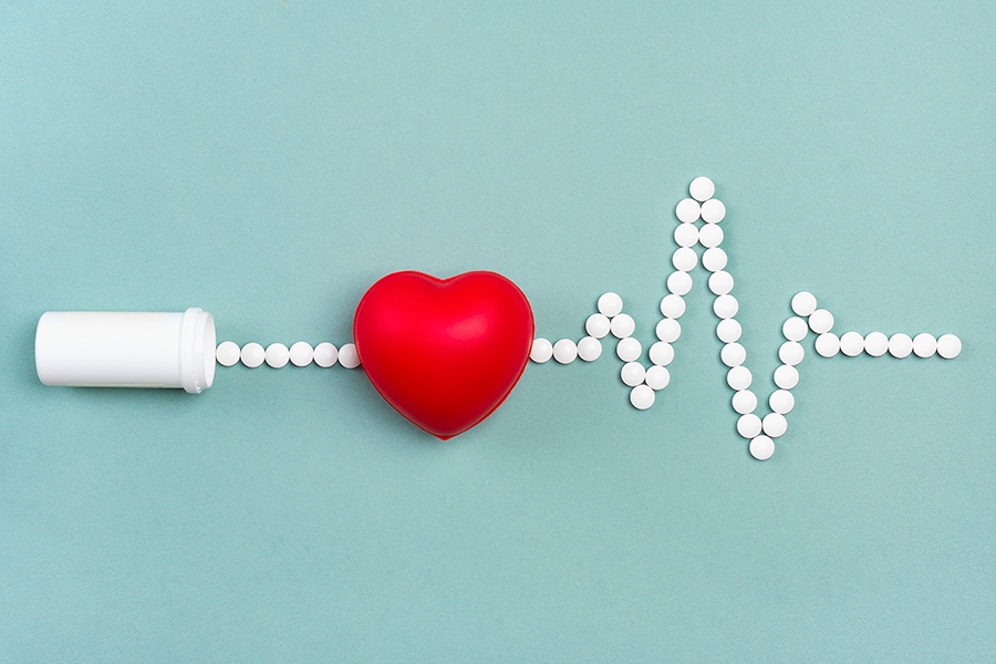 plastikowe serce i linia EKG z tabletek